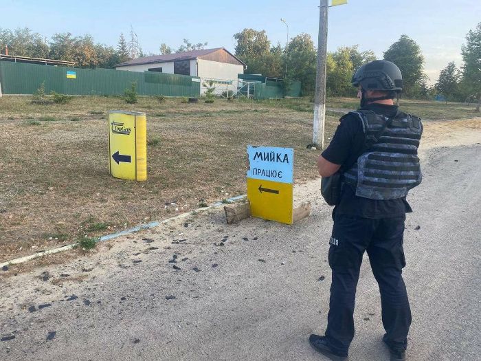 Силовик стоит на дороге возле таблички с надписью "Мийка"